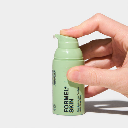 Person wendet Das Leave-on-Peeling an, zeigt die richtige Anwendungstechnik und Textur des Produkts.